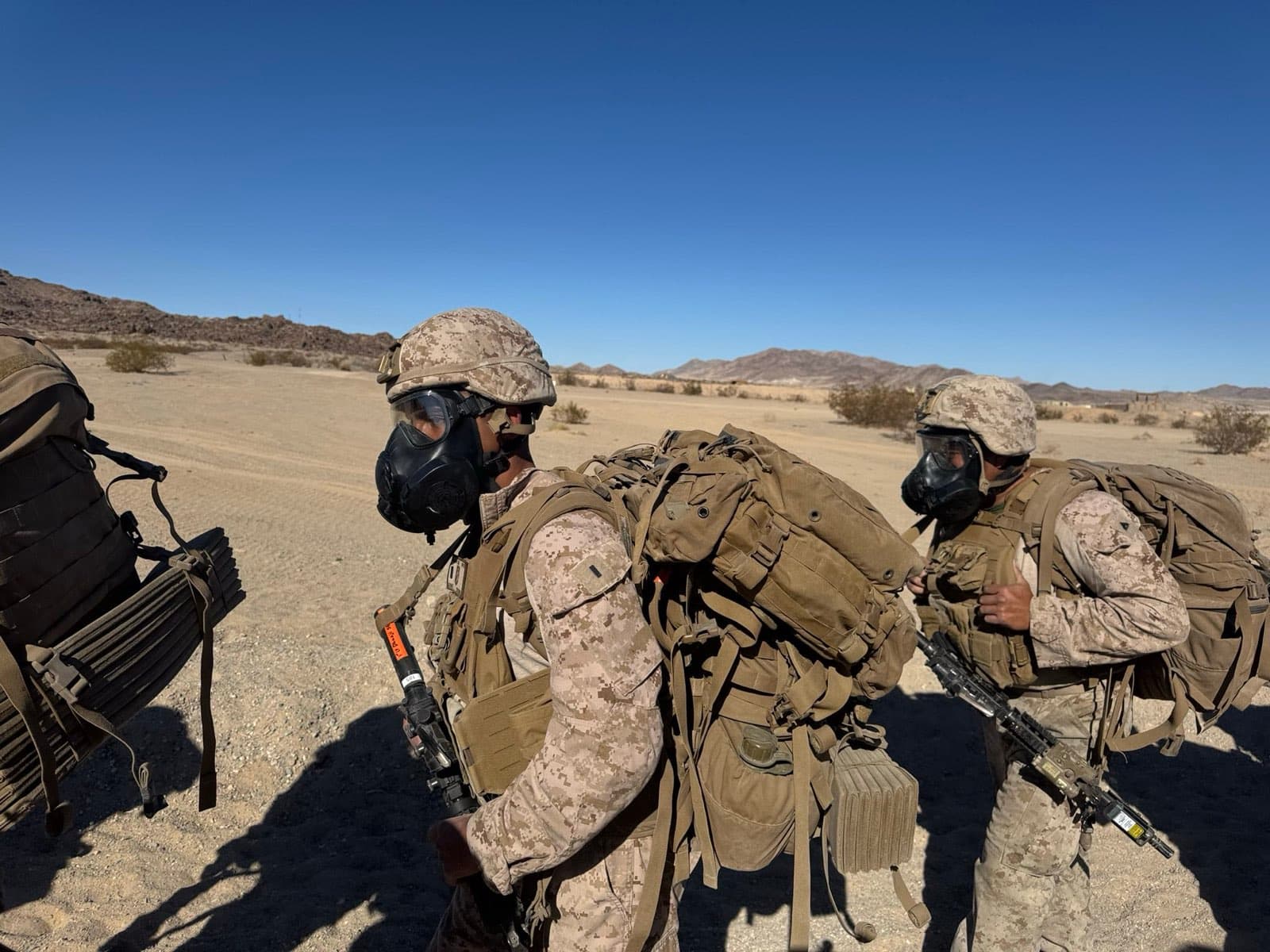 Marines conducting training with full combat load in desert terrain